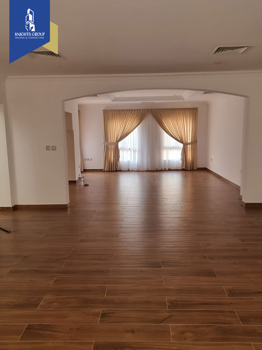 Spacious living area in a renovated villa at Alfardan Garden 01, Doha, featuring new flooring, curtains, and ample natural light.